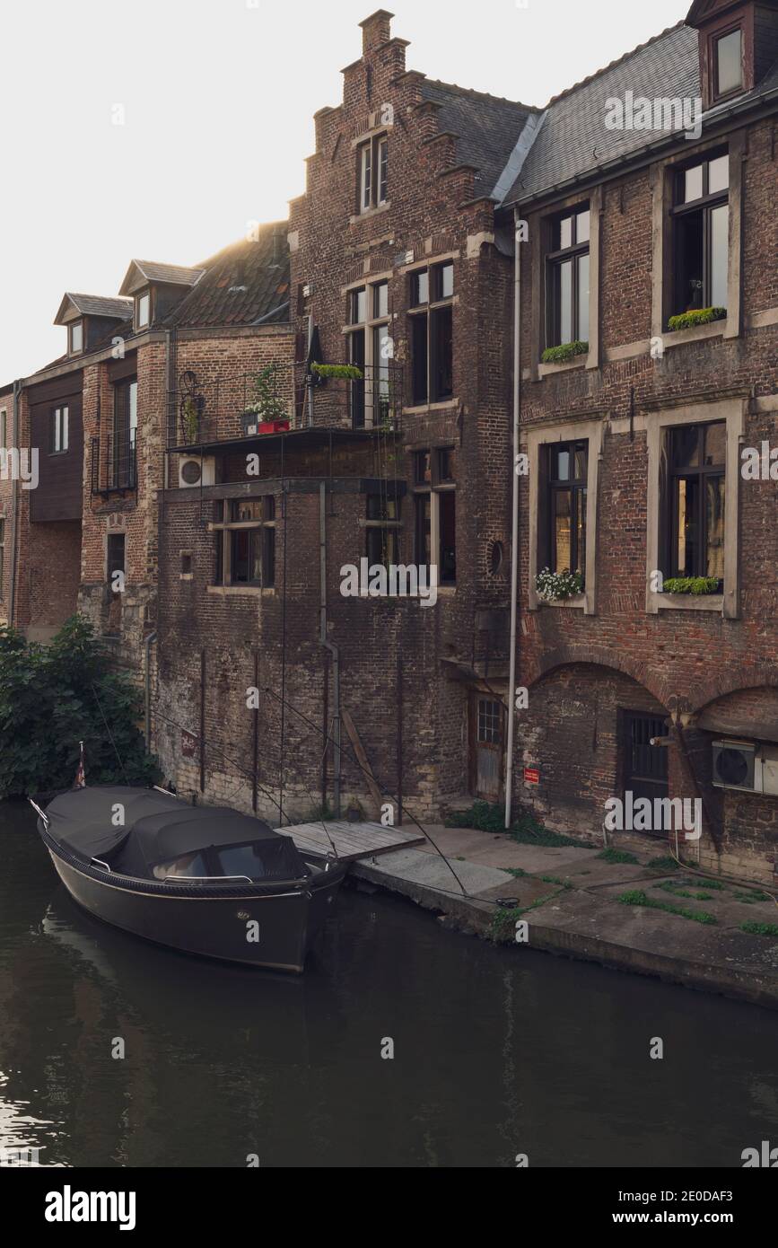 Residential house with brick walls located near canal with moored boat in city Stock Photo