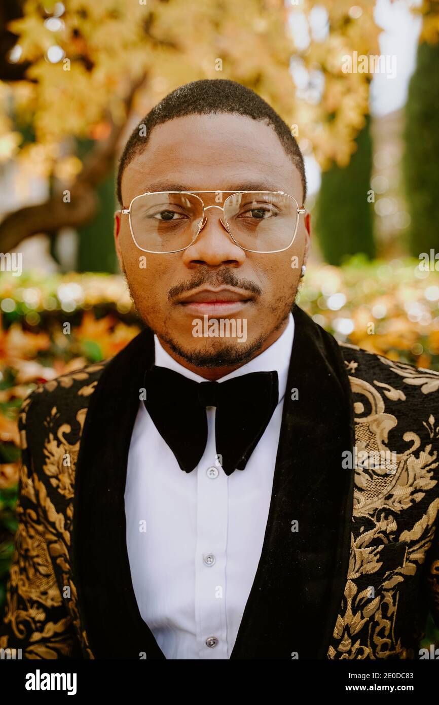 Elegant African American male wearing expensive tuxedo walking along street and looking at camera Stock Photo Alamy