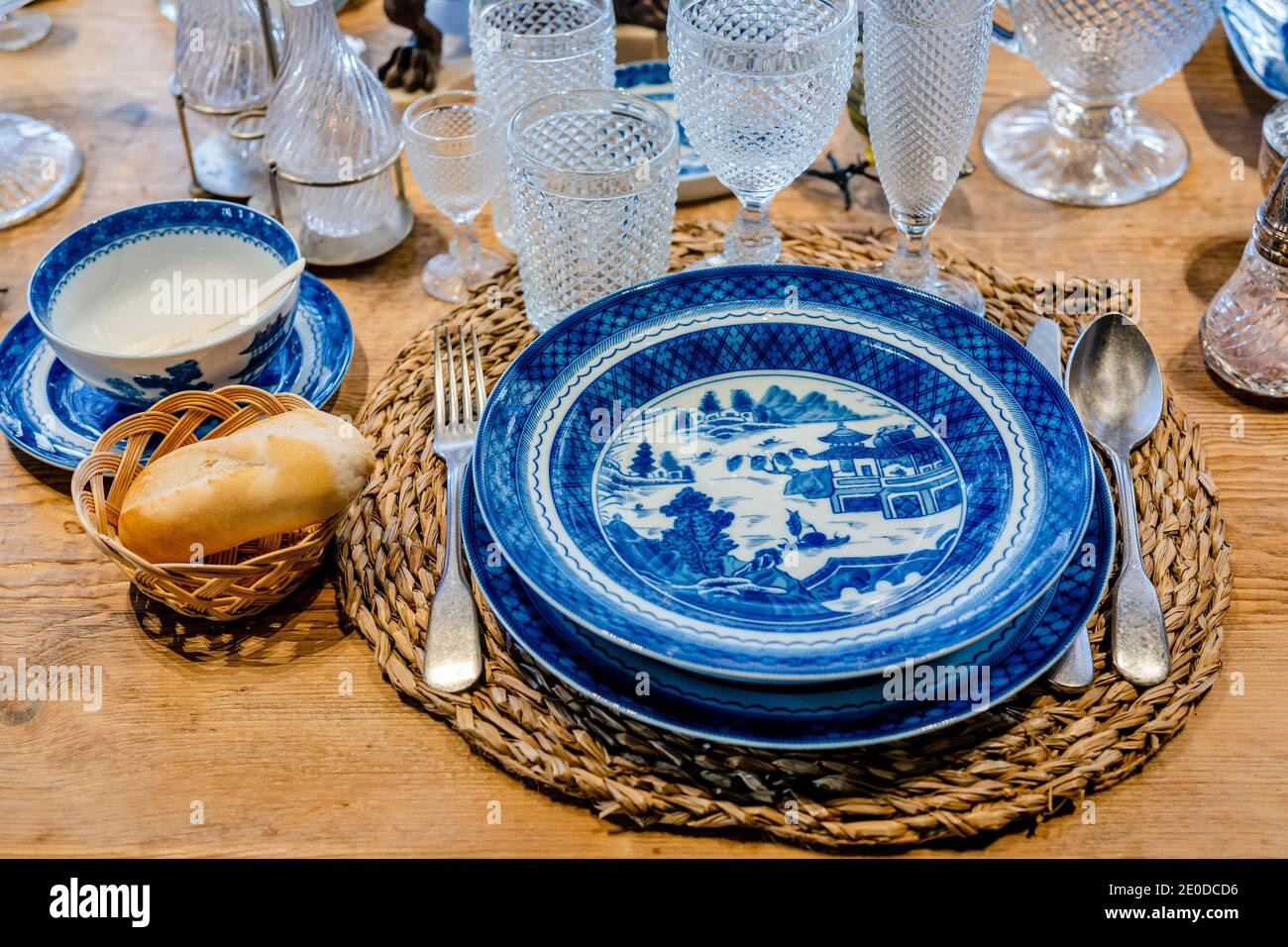 From above of blue ceramic plates served on wooden table with elegant glassware and silverware Stock Photo