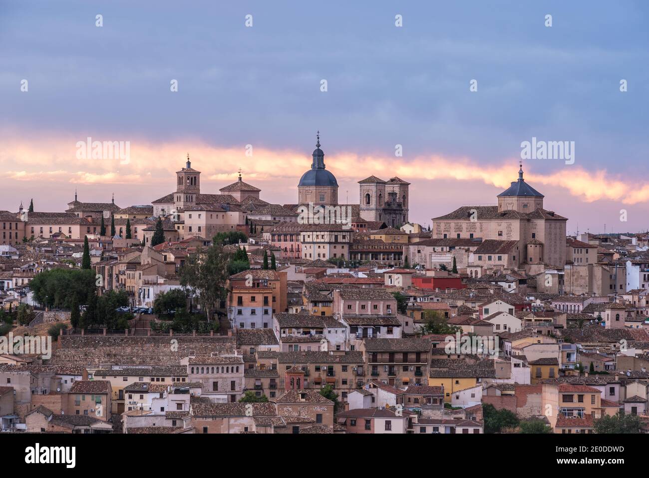 Amazing cityscape with aged stone buildings located on hill on background of cloudy sky in evening Stock Photo