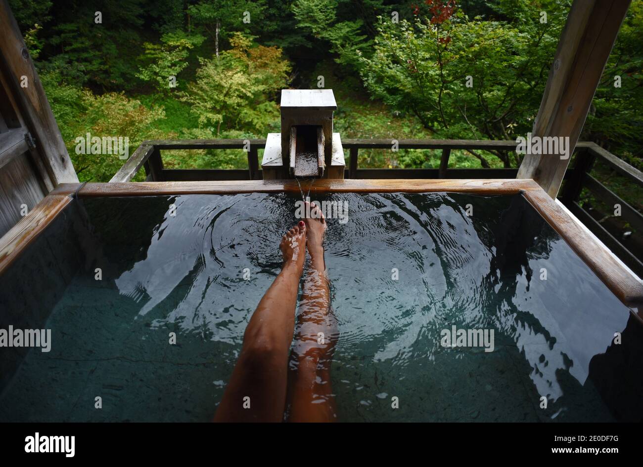 Legs and feet of caucasian female traveler enjoying a thermal waters