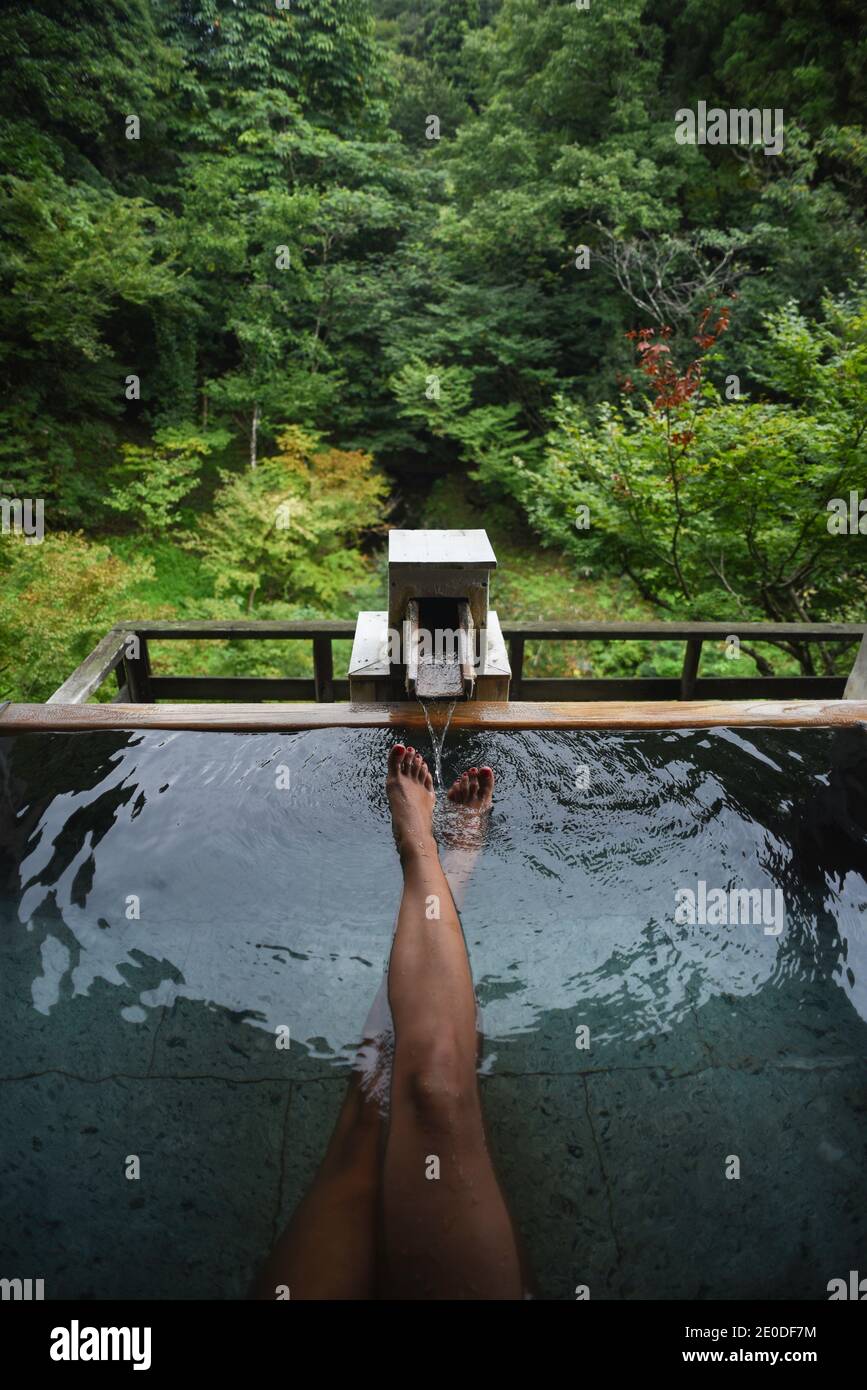 Legs and feet of caucasian female traveler enjoying a thermal waters
