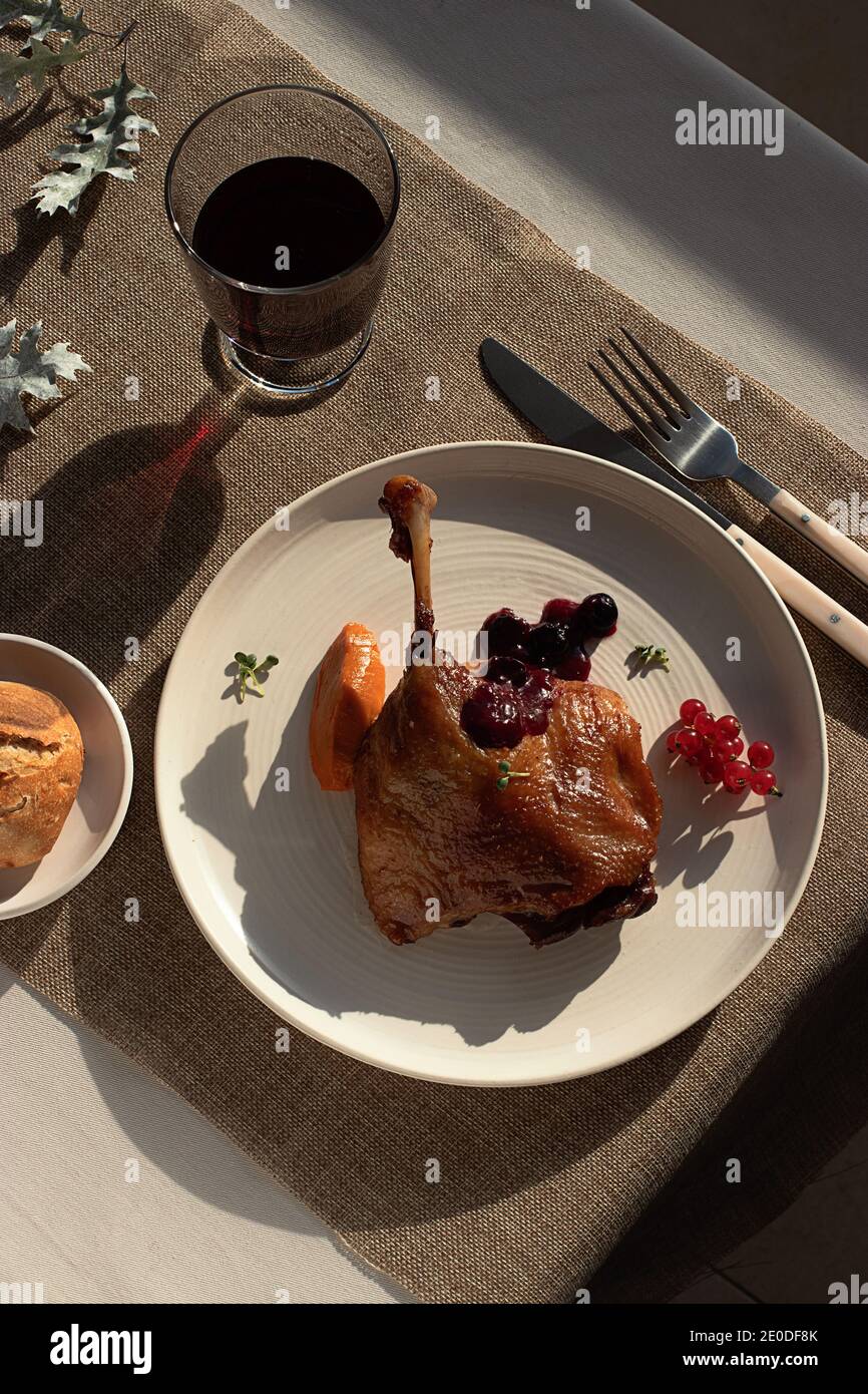 From above delicious fried duck confit on white ceramic plate placed on