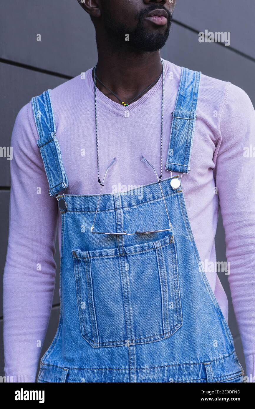Crop anonymous African American male wearing denim overalls and