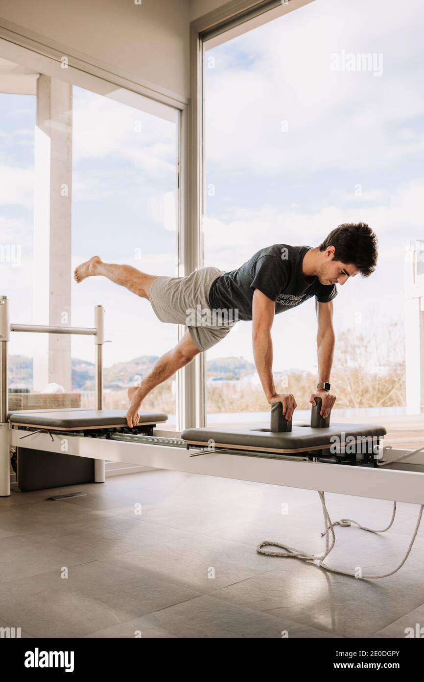 Side view of concentrated male balancing in Eka Pada Phalakasana on