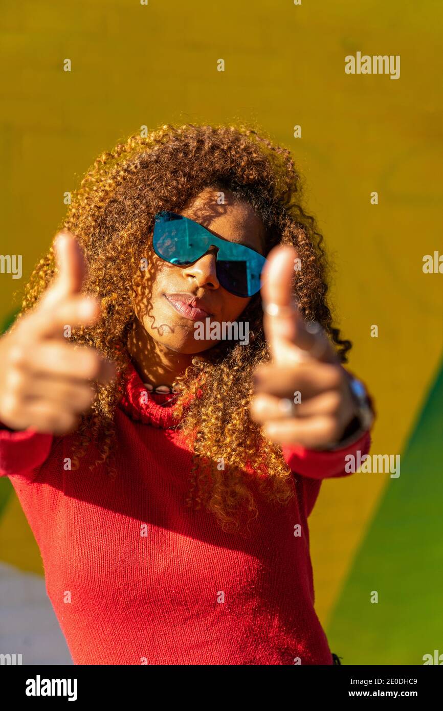 Cheerful young African American female with curly hair in casual ...