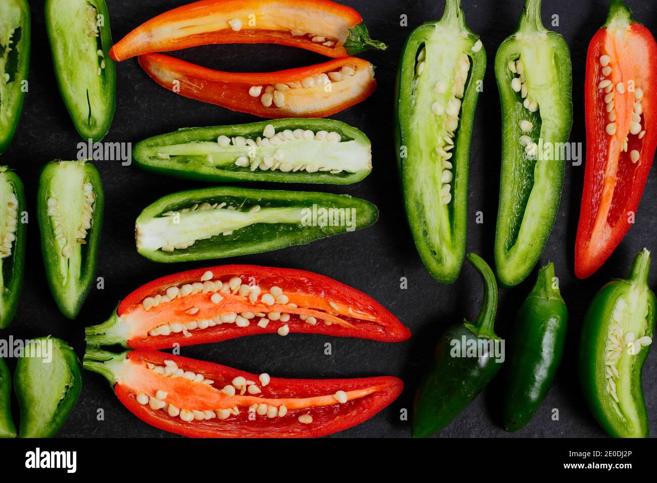 Ripe homegrown red and green jalapeno chilli peppers sliced open to reveal seeds and membranes. UK Stock Photo