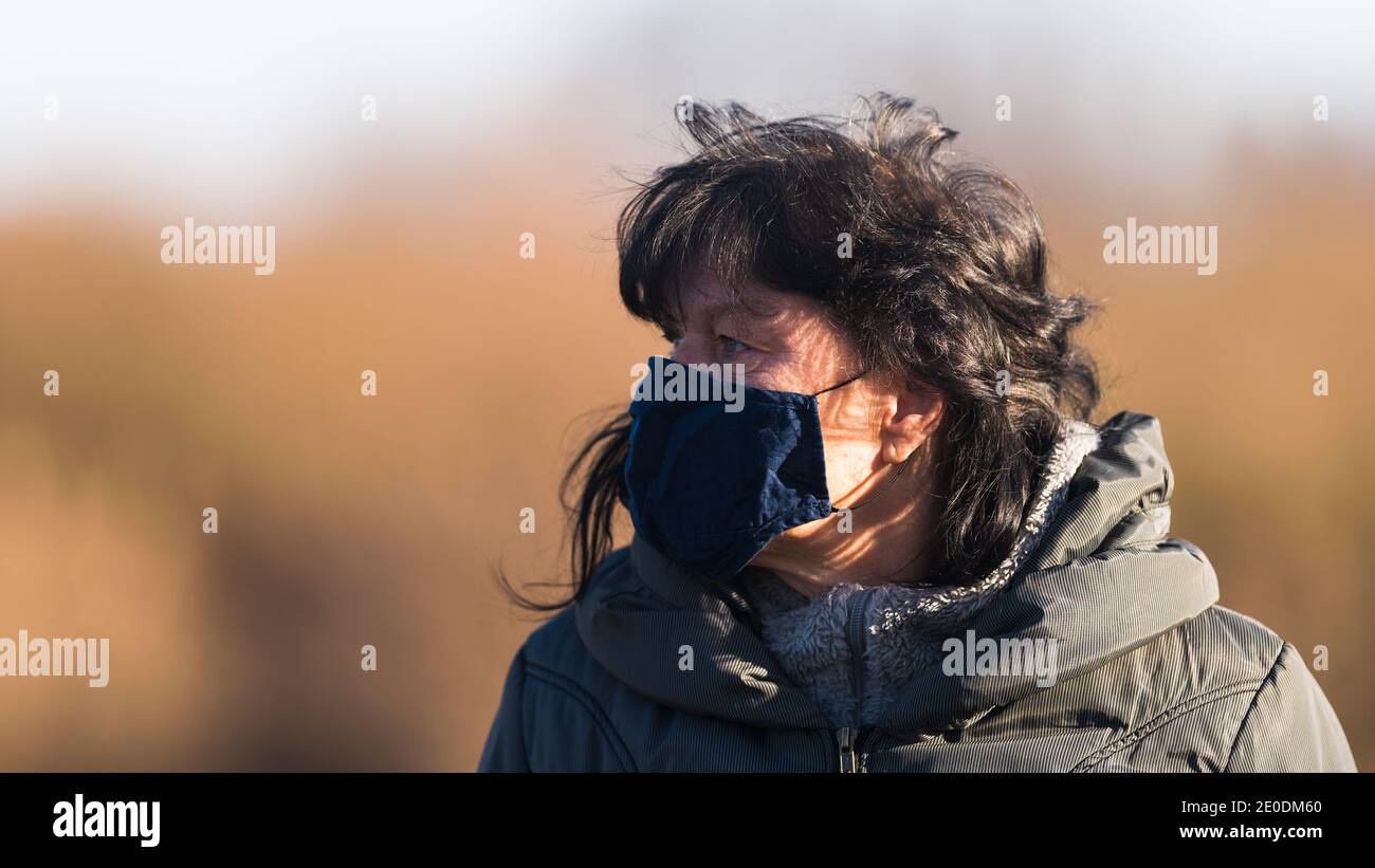 Side portrait of a woman with a protective mask against corona Stock Photo