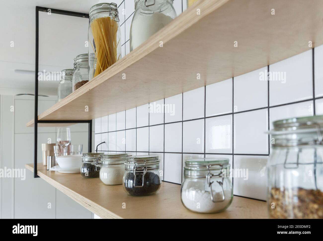 Custom made plywood shelves on a white tiled kitchen wall Stock Photo Alamy