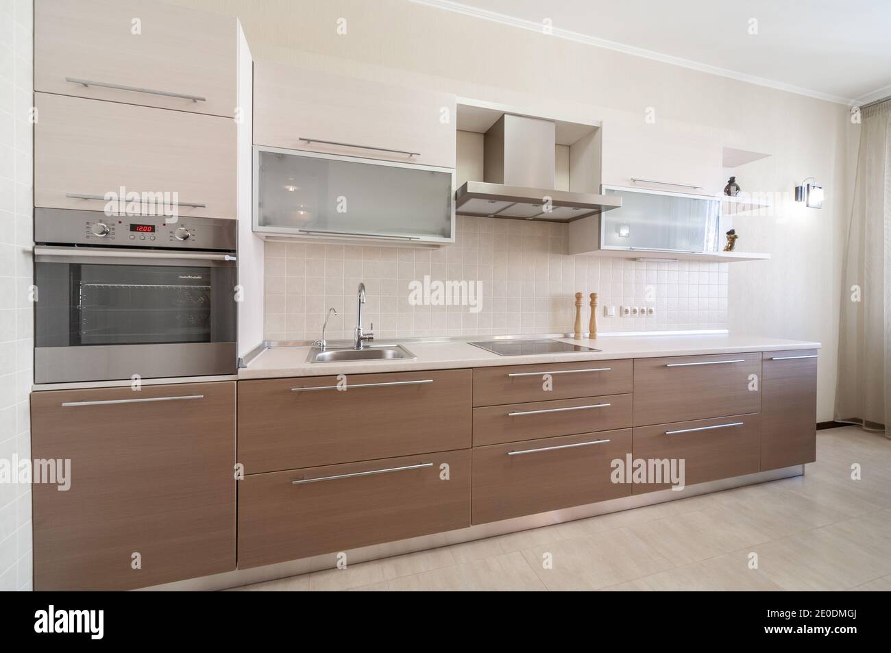 Modern kitchen interior with beige and light brown faсade pannels. Kitchen design concept Stock Photo