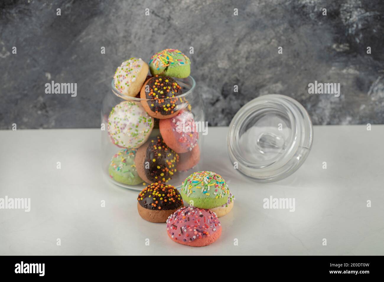 A glass jar full of small colorful doughnuts Stock Photo