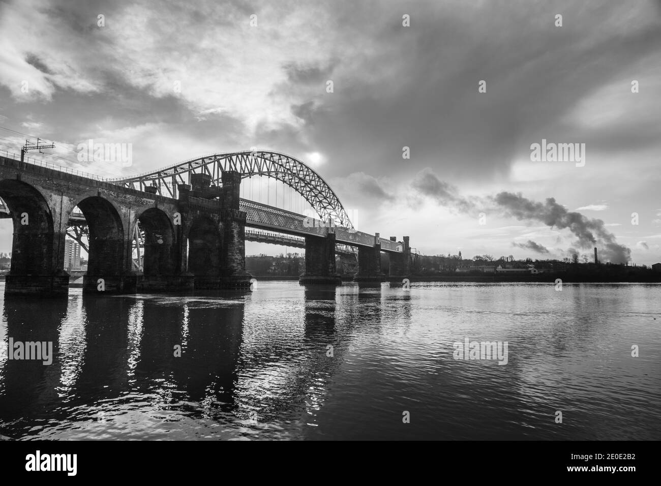 The Runcorn Railway Bridge  (foreground) and the Silver Jubilee Bridge (background) captured in black and white in December 2020. Stock Photo