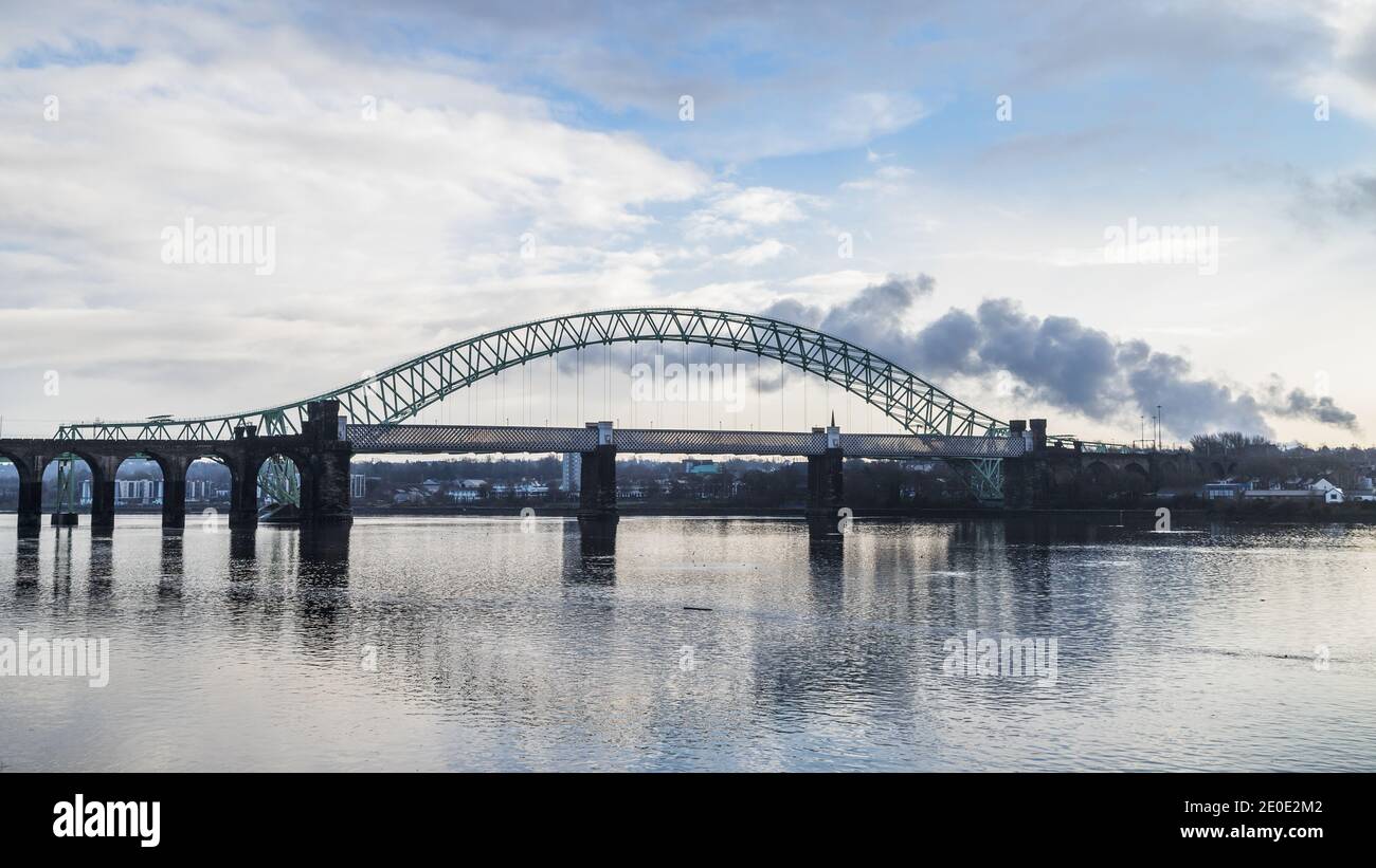 The iconic bridges linking Runcorn and Widness span the Mersey Estuary.  The Runcorn Railway Bridge sits closest to the camera and the Silver Jubilee Stock Photo