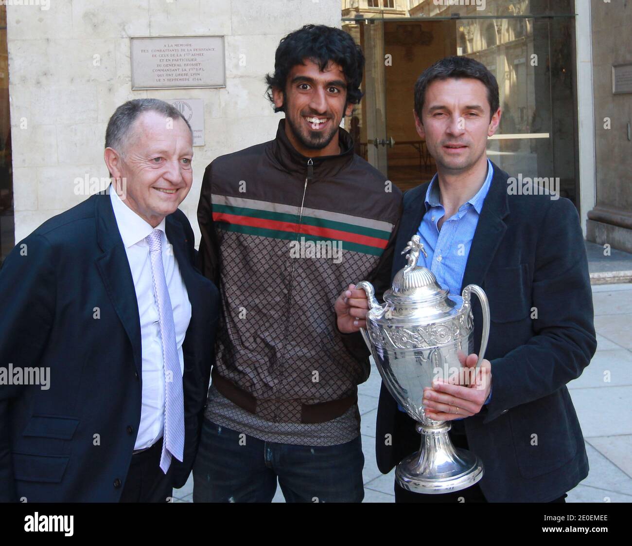 OL's new player Hamdan Al Kamali, president Jean Michel Aulas and coach  Remi Garde celebrate holding the trophy in front of supporters at the City  Hall in Lyon, France on April 29,