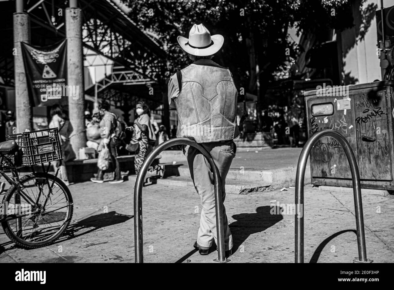 HERMOSILLO, MEXICO DECEMBER 31: A cowboy in a fur vest and hat rests leaning against the bicycle parking meter at the entrance to the Hermosillo Municipal Market. Daily life of beautiful people in the streets of the city center during the last day of the year, on December 31, 2020 in Hermosillo, Mexico .. (Photo by Luis Gutierrez / Norte Photo)  HERMOSILLO, MEXICO DICIEMBRE 31: Un vaquero con chaleco de piel  y sombrero descansa recargado en el parquimetro de bicicletas en la entrada del Mercado Municipal de Hermosillo. Vida cotidiana de hermosillences en las calles del centro de la ciudad dur Stock Photo