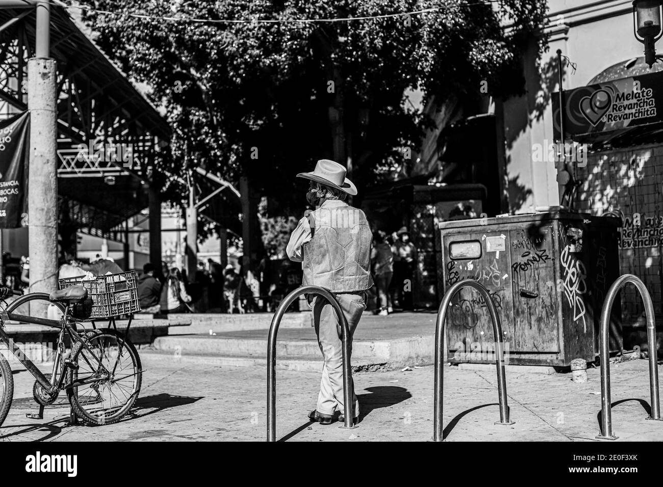 HERMOSILLO, MEXICO DECEMBER 31: A cowboy in a fur vest and hat rests leaning against the bicycle parking meter at the entrance to the Hermosillo Municipal Market. Daily life of beautiful people in the streets of the city center during the last day of the year, on December 31, 2020 in Hermosillo, Mexico .. (Photo by Luis Gutierrez / Norte Photo)  HERMOSILLO, MEXICO DICIEMBRE 31: Un vaquero con chaleco de piel  y sombrero descansa recargado en el parquimetro de bicicletas en la entrada del Mercado Municipal de Hermosillo. Vida cotidiana de hermosillences en las calles del centro de la ciudad dur Stock Photo