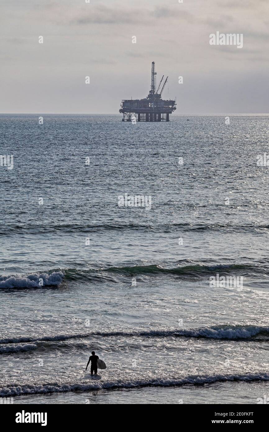 Oil Derrick and surfers off coast of Huntington Beach, Orange County, California, USA Stock Photo