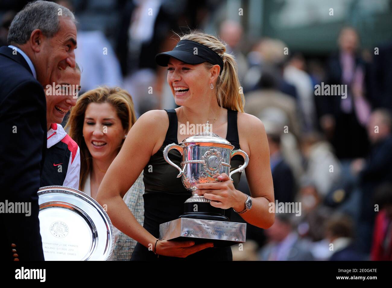 Russia's Maria Sharapova and Italy's Sara Errani hold their trophies recieved from former tennis Monica Seles and Jean Gachassin on the podium after their Women's Singles final tennis of the