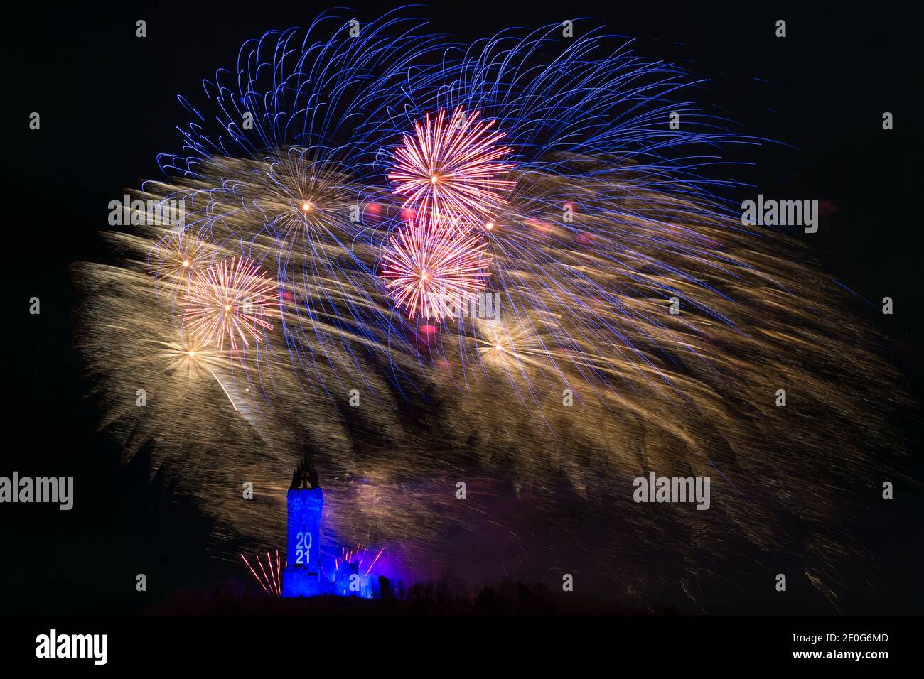 Stirling, Scotland, UK. 1st Jan, 2021. Pictured: Hogmanay pyrotechnic spectacular closes off 2020 and brings in 2021 with a bang as colourful explosions burst lighting up the new year night sky 600feet above the Wallace Monument in Stirling. Due to the coronavirus (COVID19) pandemic the show will be live streamed on TV and online since Scotland is in phase 4 lockdown. Edinburgh based events company, 21CC Events Ltd, pyrotechnic specialists have spent the last few days setting up the show including powerful projection lights for the monuments facade. Credit: Colin Fisher/Alamy Live News Stock Photo