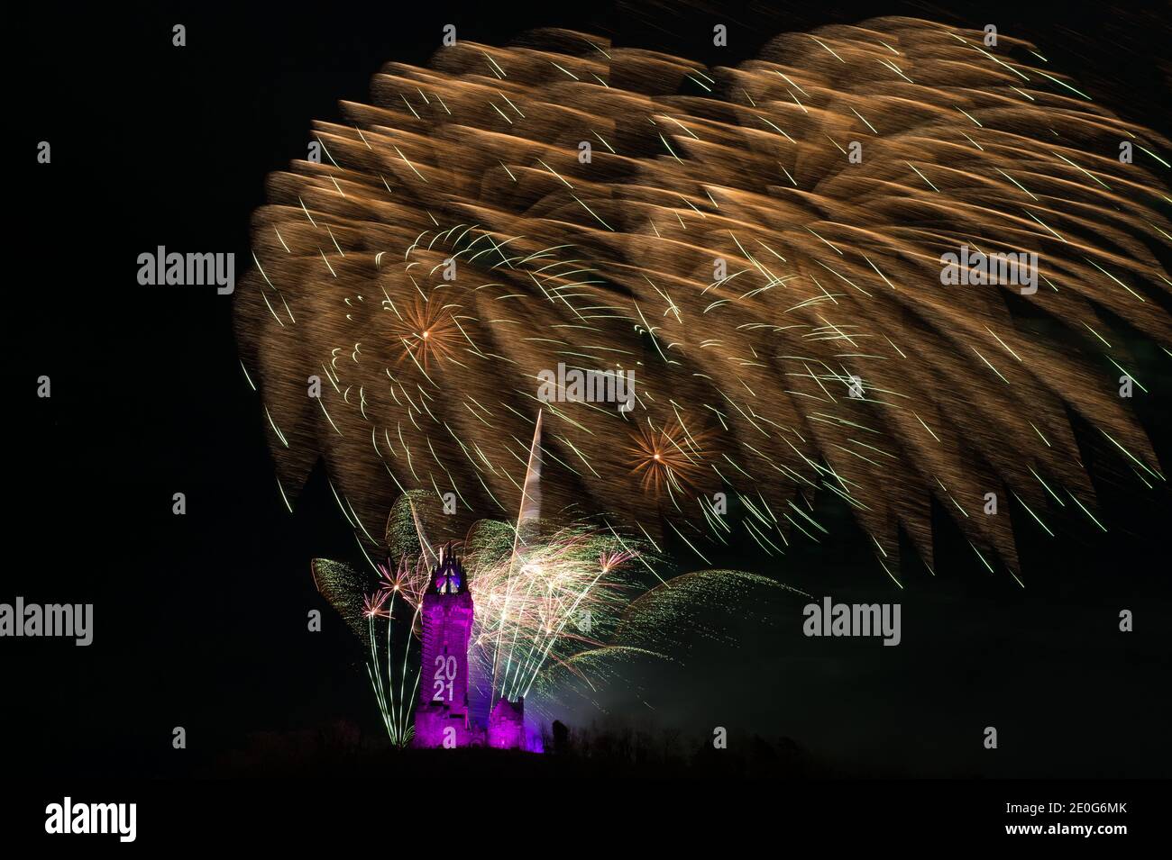 Stirling, Scotland, UK. 1st Jan, 2021. Pictured: Hogmanay pyrotechnic spectacular closes off 2020 and brings in 2021 with a bang as colourful explosions burst lighting up the new year night sky 600feet above the Wallace Monument in Stirling. Due to the coronavirus (COVID19) pandemic the show will be live streamed on TV and online since Scotland is in phase 4 lockdown. Edinburgh based events company, 21CC Events Ltd, pyrotechnic specialists have spent the last few days setting up the show including powerful projection lights for the monuments facade. Credit: Colin Fisher/Alamy Live News Stock Photo