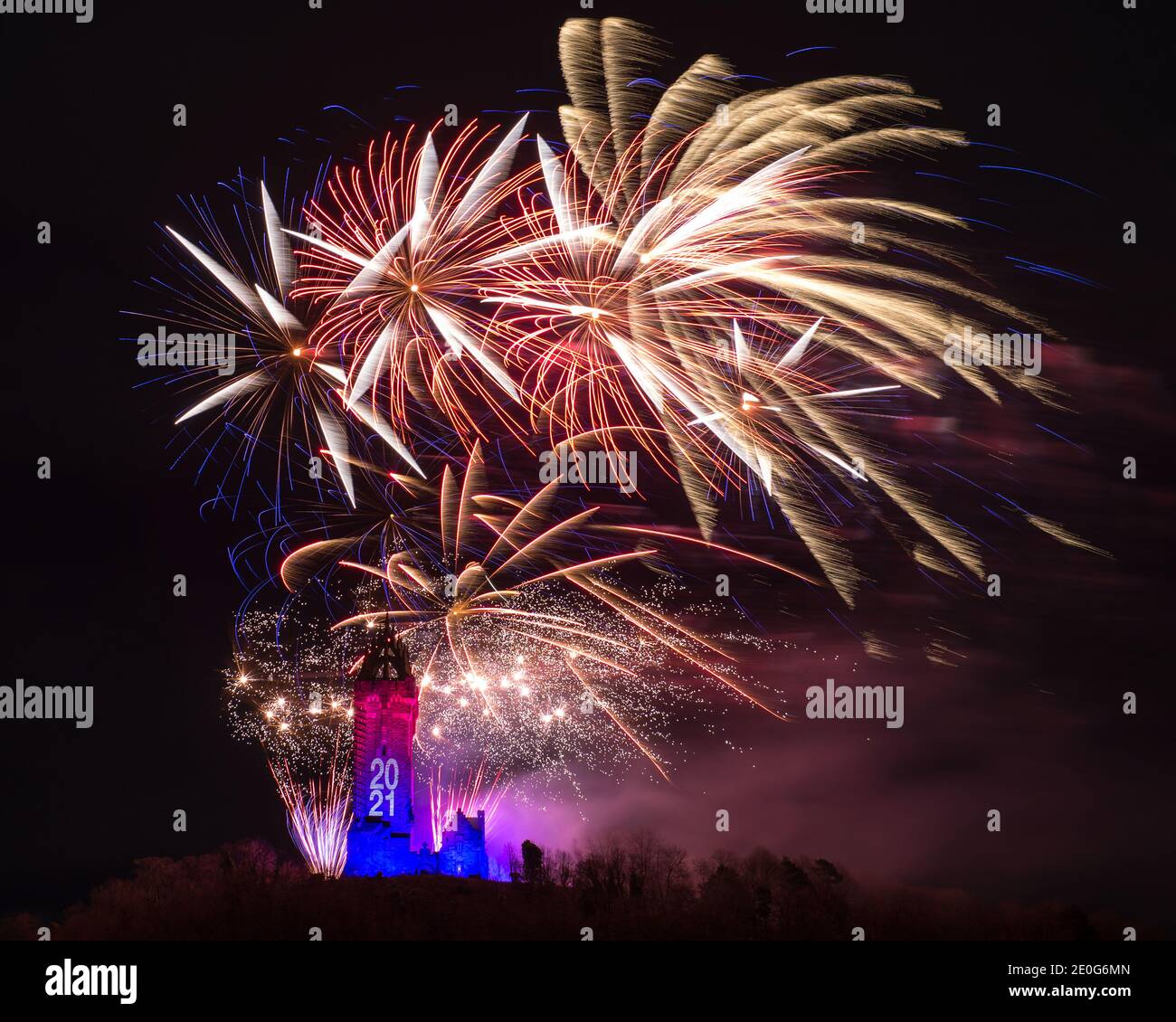 Stirling, Scotland, UK. 1st Jan, 2021. Pictured: Hogmanay pyrotechnic spectacular closes off 2020 and brings in 2021 with a bang as colourful explosions burst lighting up the new year night sky 600feet above the Wallace Monument in Stirling. Due to the coronavirus (COVID19) pandemic the show will be live streamed on TV and online since Scotland is in phase 4 lockdown. Edinburgh based events company, 21CC Events Ltd, pyrotechnic specialists have spent the last few days setting up the show including powerful projection lights for the monuments facade. Credit: Colin Fisher/Alamy Live News Stock Photo