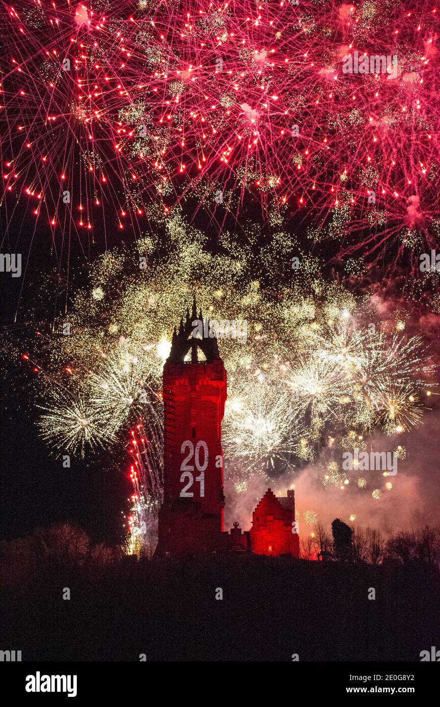 Stirling, Scotland, UK. 1st Jan, 2021. Pictured: Hogmanay pyrotechnic spectacular closes off 2020 and brings in 2021 with a bang as colourful explosions burst lighting up the new year night sky 600feet above the Wallace Monument in Stirling. Due to the coronavirus (COVID19) pandemic the show will be live streamed on TV and online since Scotland is in phase 4 lockdown. Edinburgh based events company, 21CC Events Ltd, pyrotechnic specialists have spent the last few days setting up the show including powerful projection lights for the monuments facade. Credit: Colin Fisher/Alamy Live News Stock Photo