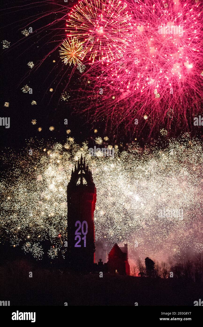 Stirling, Scotland, UK. 1st Jan, 2021. Pictured: Hogmanay pyrotechnic spectacular closes off 2020 and brings in 2021 with a bang as colourful explosions burst lighting up the new year night sky 600feet above the Wallace Monument in Stirling. Due to the coronavirus (COVID19) pandemic the show will be live streamed on TV and online since Scotland is in phase 4 lockdown. Edinburgh based events company, 21CC Events Ltd, pyrotechnic specialists have spent the last few days setting up the show including powerful projection lights for the monuments facade. Credit: Colin Fisher/Alamy Live News Stock Photo