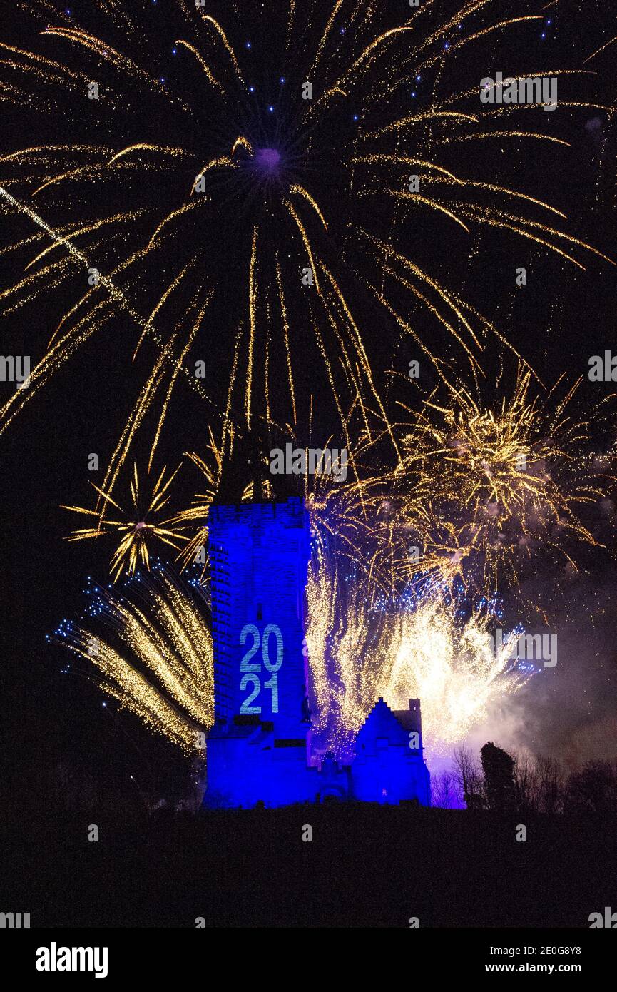 Stirling, Scotland, UK. 1st Jan, 2021. Pictured: Hogmanay pyrotechnic spectacular closes off 2020 and brings in 2021 with a bang as colourful explosions burst lighting up the new year night sky 600feet above the Wallace Monument in Stirling. Due to the coronavirus (COVID19) pandemic the show will be live streamed on TV and online since Scotland is in phase 4 lockdown. Edinburgh based events company, 21CC Events Ltd, pyrotechnic specialists have spent the last few days setting up the show including powerful projection lights for the monuments facade. Credit: Colin Fisher/Alamy Live News Stock Photo