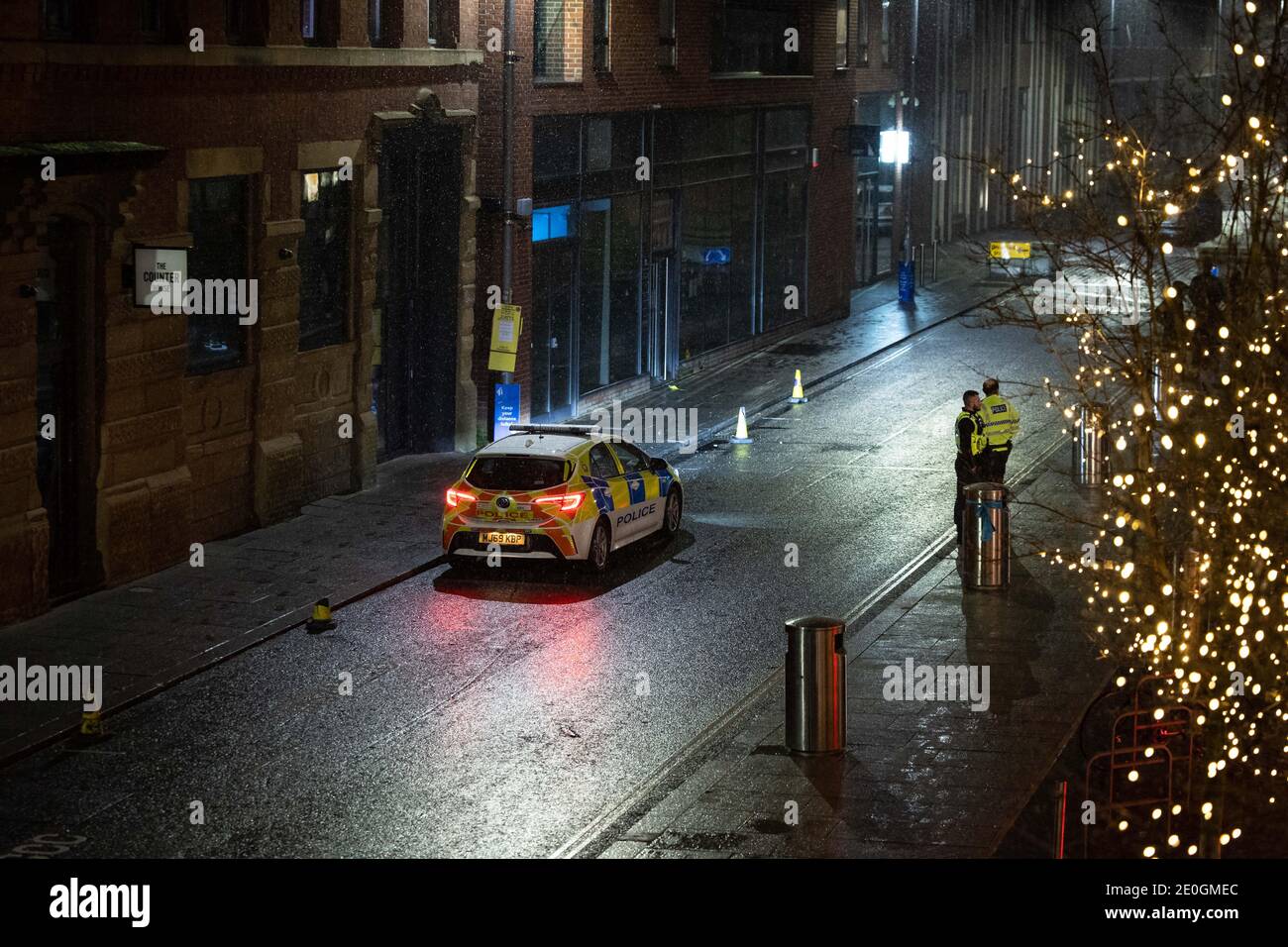 MANCHESTER, UK Police watch on as revellers celebrate New Year outside in the sleet in Cutting Room Square, Ancoats, Manchester city centre on Friday 1st January 2021. (Credit: Pat Scaasi | MI News) Credit: MI News & Sport /Alamy Live News Stock Photo