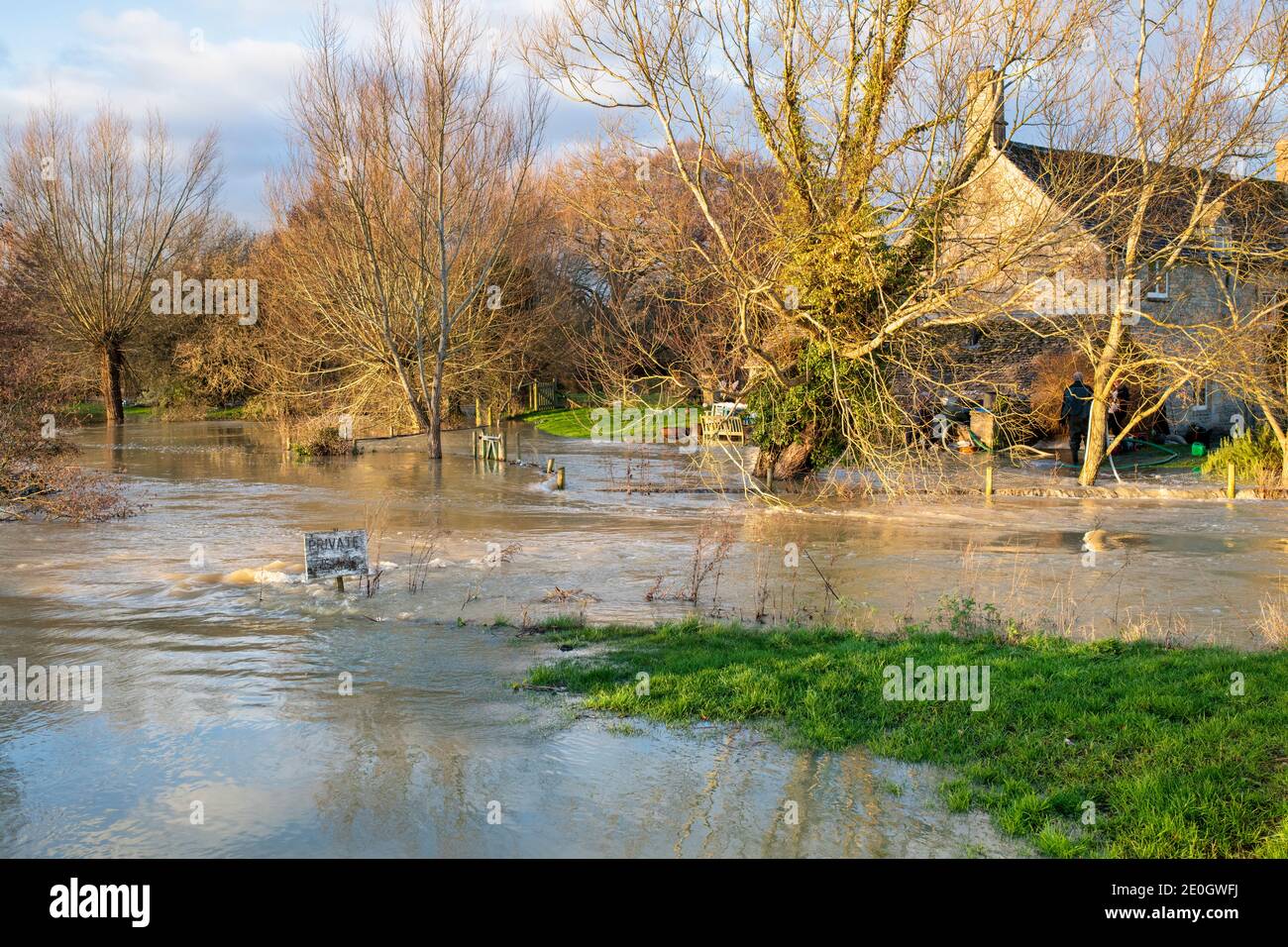 Flooded river windrush around The Swan Inn in the cotswold village of Swinbrook on christmas eve 2020. Swinbrook, Cotswolds, Oxfordshire, England Stock Photo