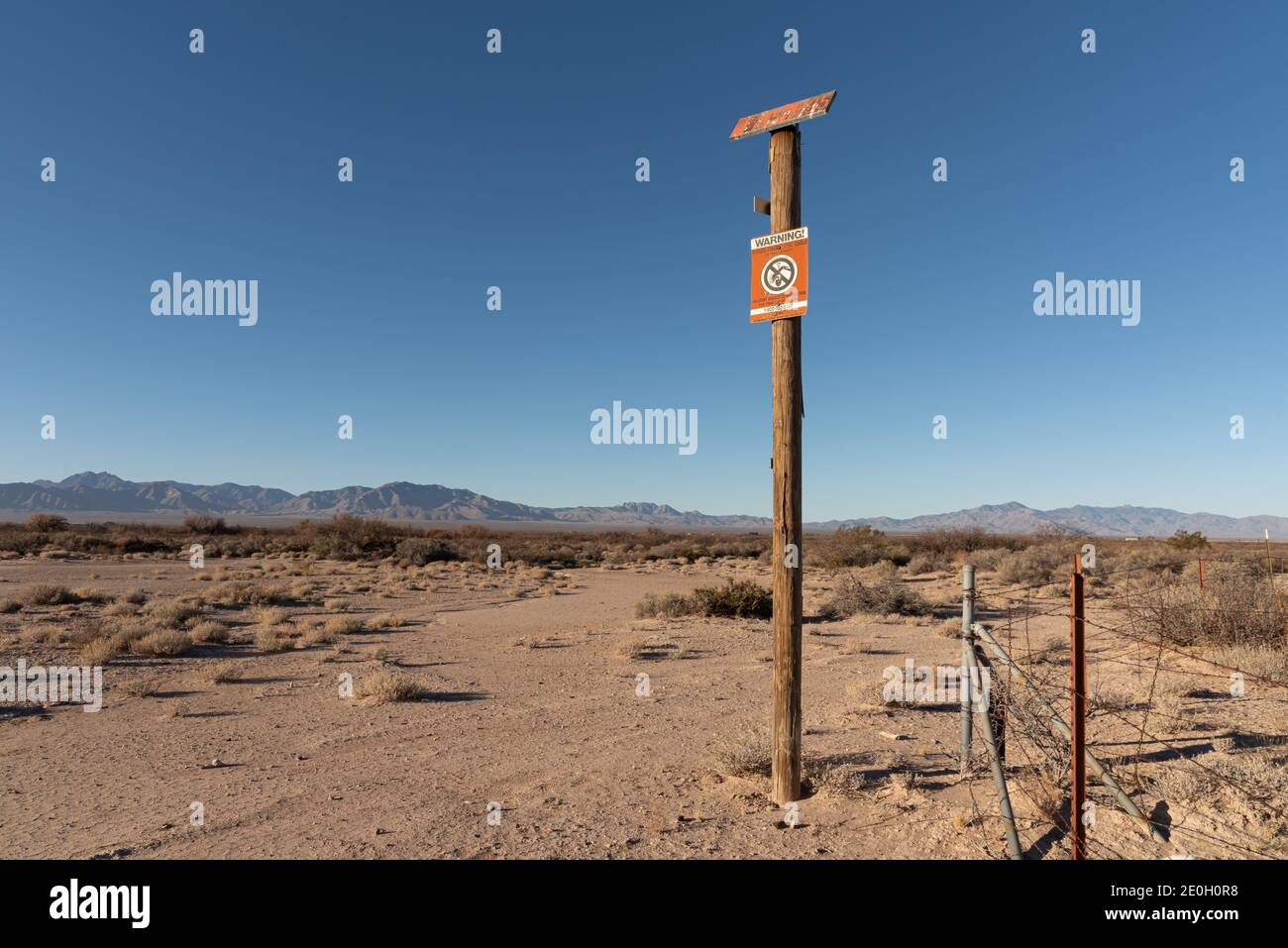 A caution sign on a tall wooden pole warns there is buried cable and no digging. Stock Photo