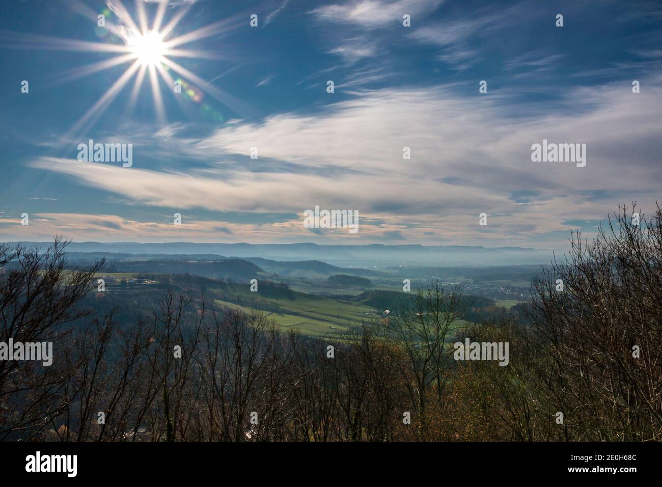 The sun shining like a star above the green countryside Stock Photo