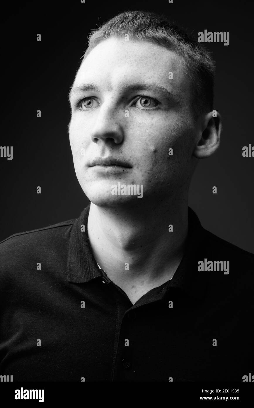 Young man against black background in black and white Stock Photo - Alamy