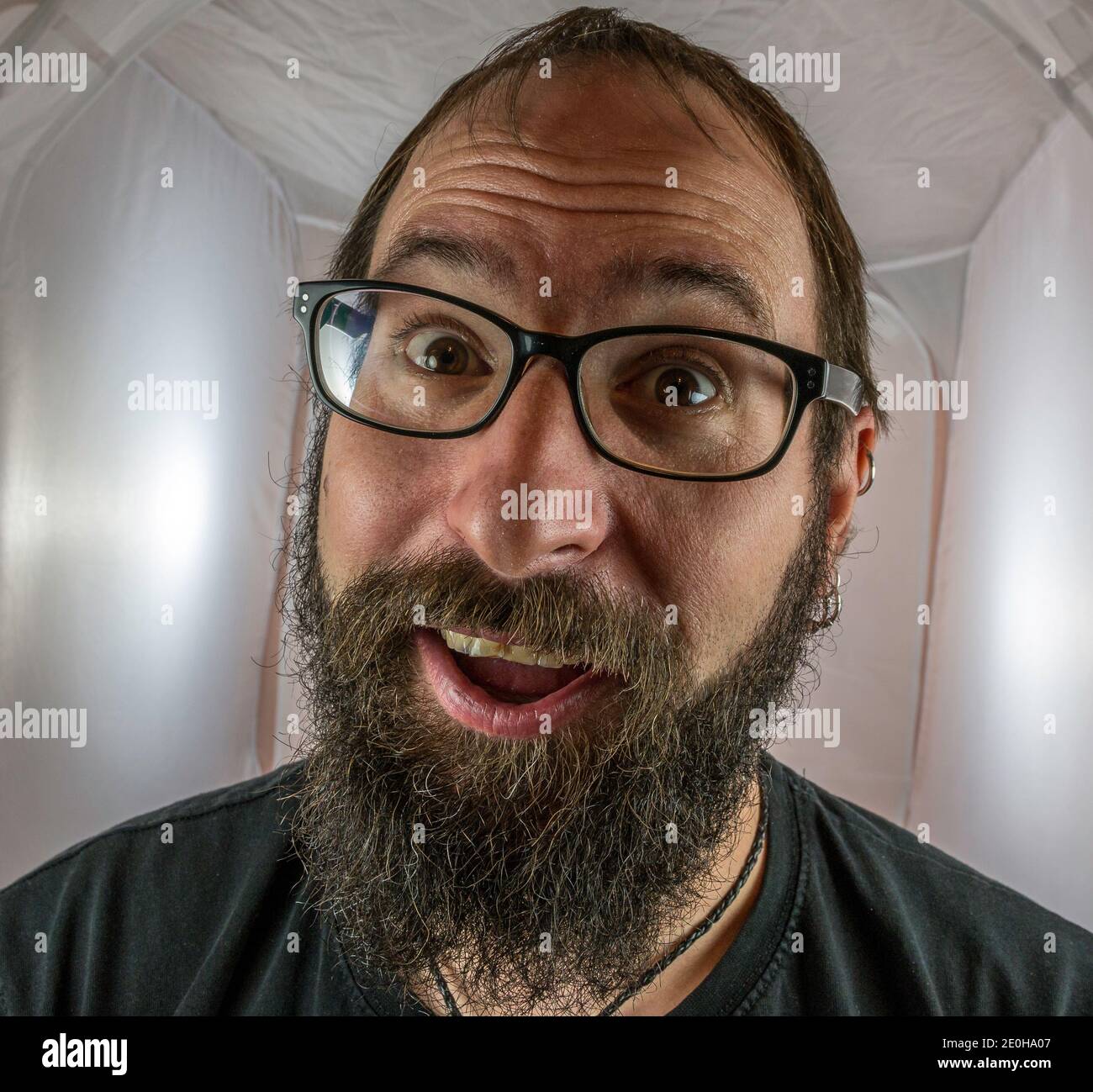 A surprised looking bearded man with glasses Stock Photo