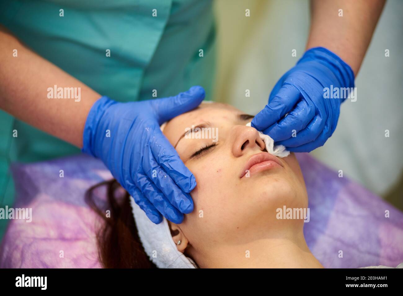 Cosmetologist masseuse cleaning woman face at spa in cosmetic