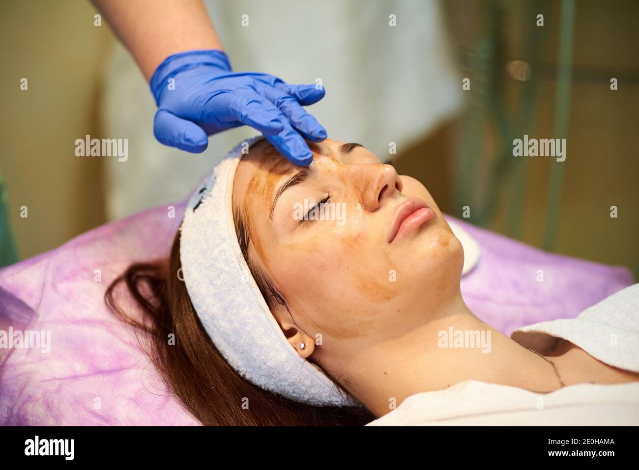 Cosmetologist masseuse cleaning woman face at spa in cosmetic