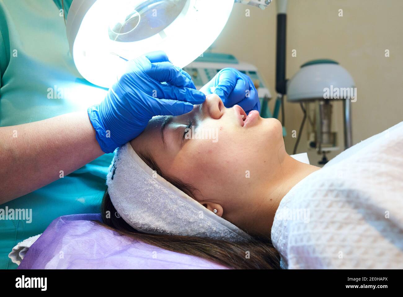 Cosmetologist masseuse cleaning woman face at spa in cosmetic