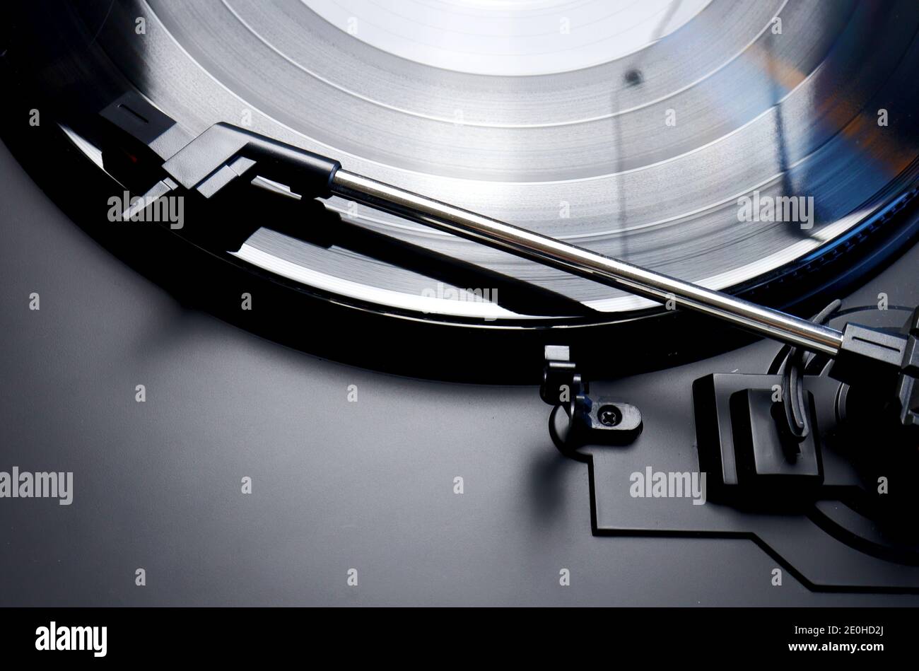 Black vinyl record spinning on a turntable - close up of a tonearm , lp and turn table Stock Photo