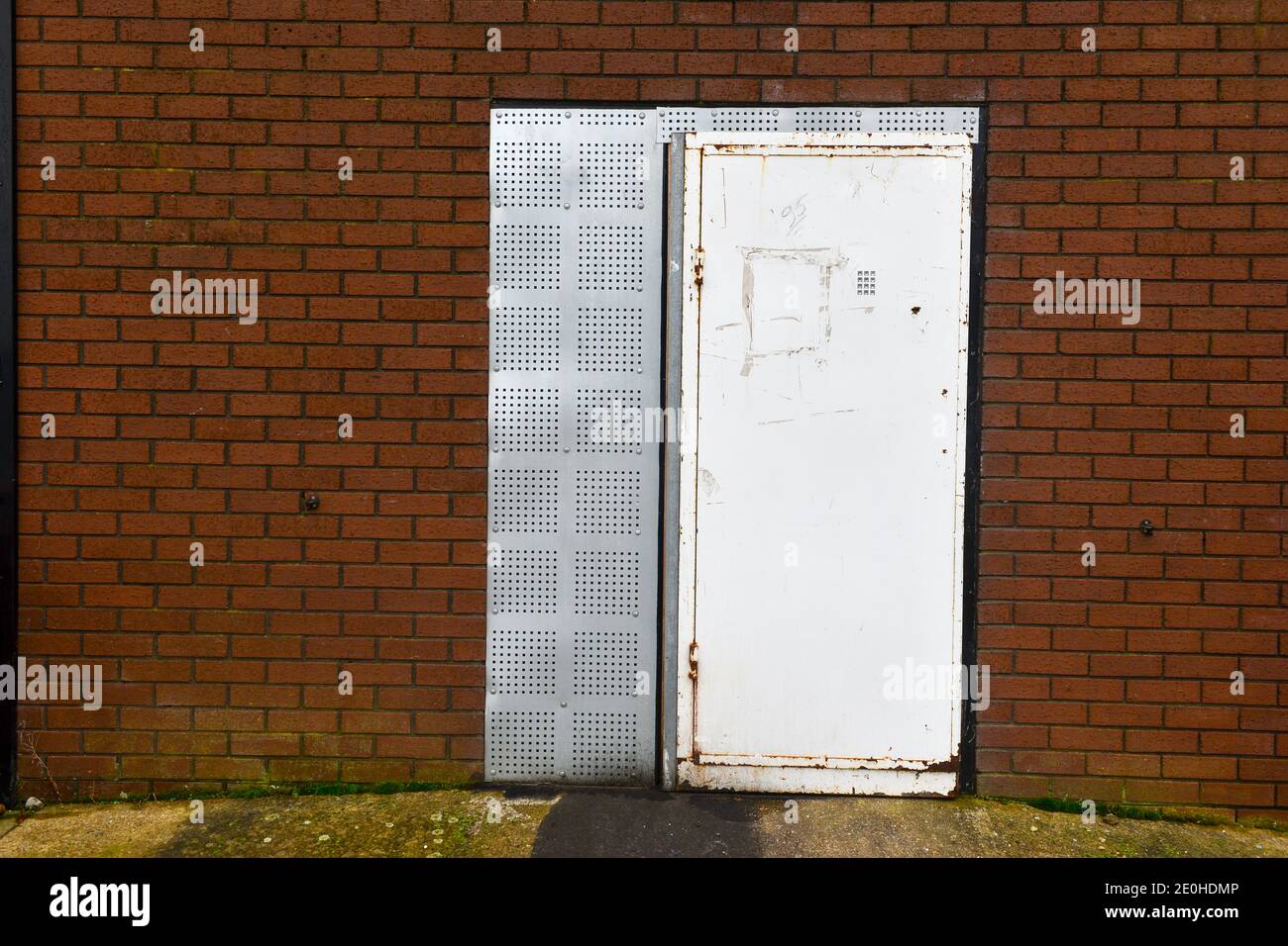 Cambridge , Uk , England, 31-12-2020, Old weathered building facade with security matal door with cut out for numbered security pad. Stock Photo