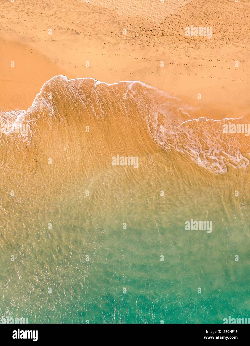 Aerial top down view of beautiful Atlantic ocean coast with crystal clear turquoise water and sandy beach, waves rolling into the shore Stock Photo