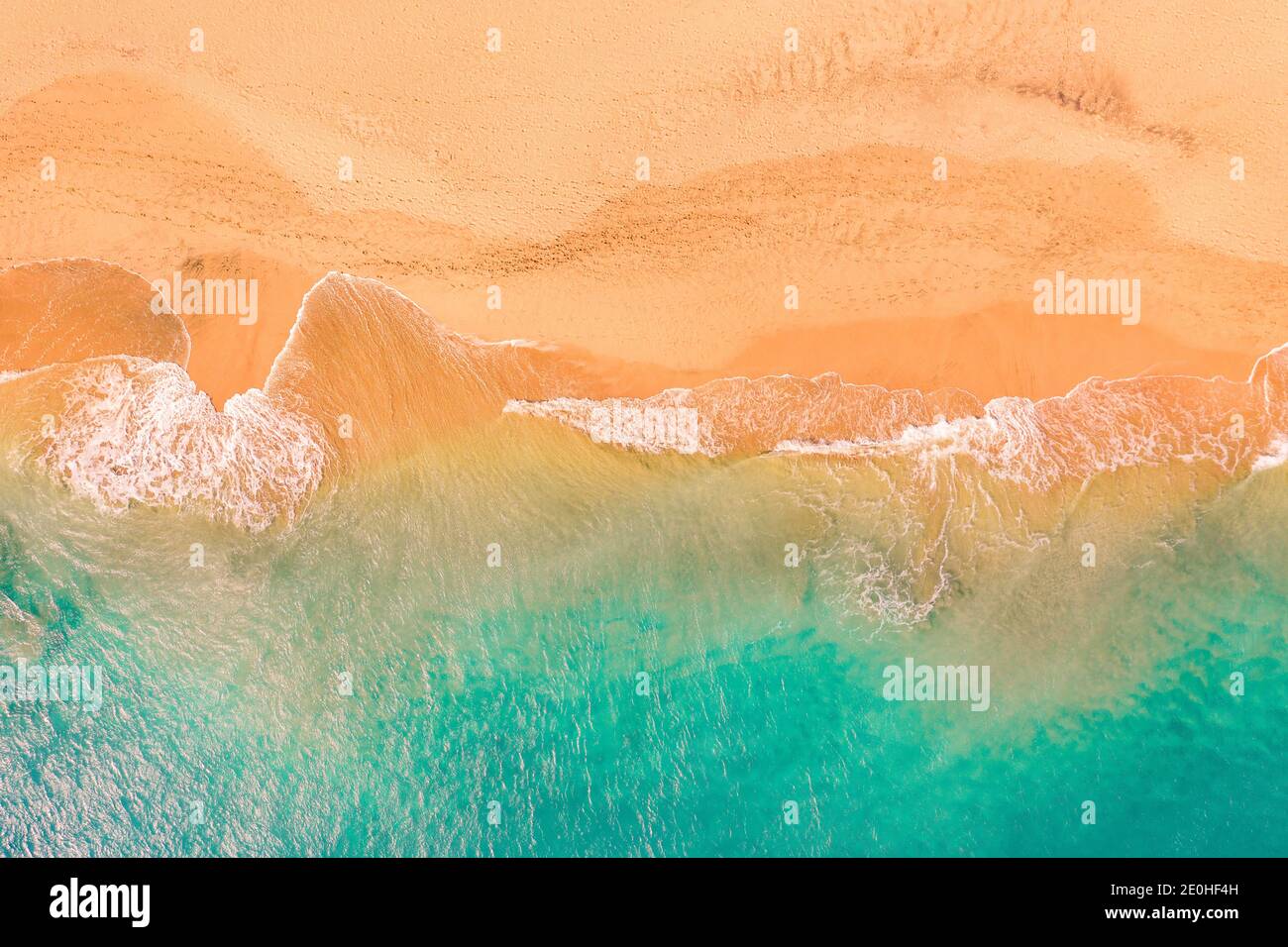 Aerial top down view of beautiful Atlantic ocean coast with crystal clear turquoise water and sandy beach, waves rolling into the shore Stock Photo