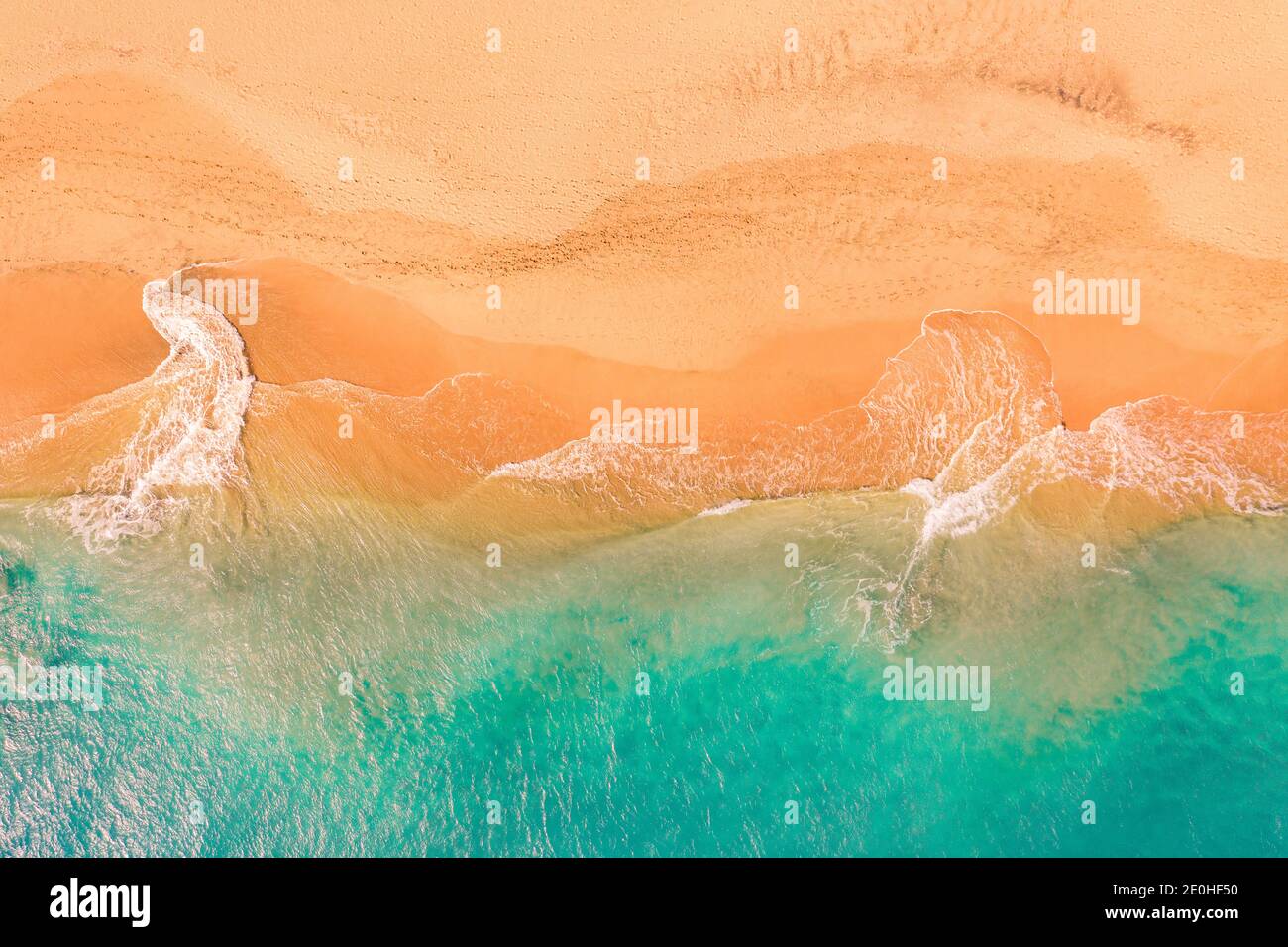 Aerial top down view of beautiful Atlantic ocean coast with crystal clear turquoise water and sandy beach, waves rolling into the shore Stock Photo