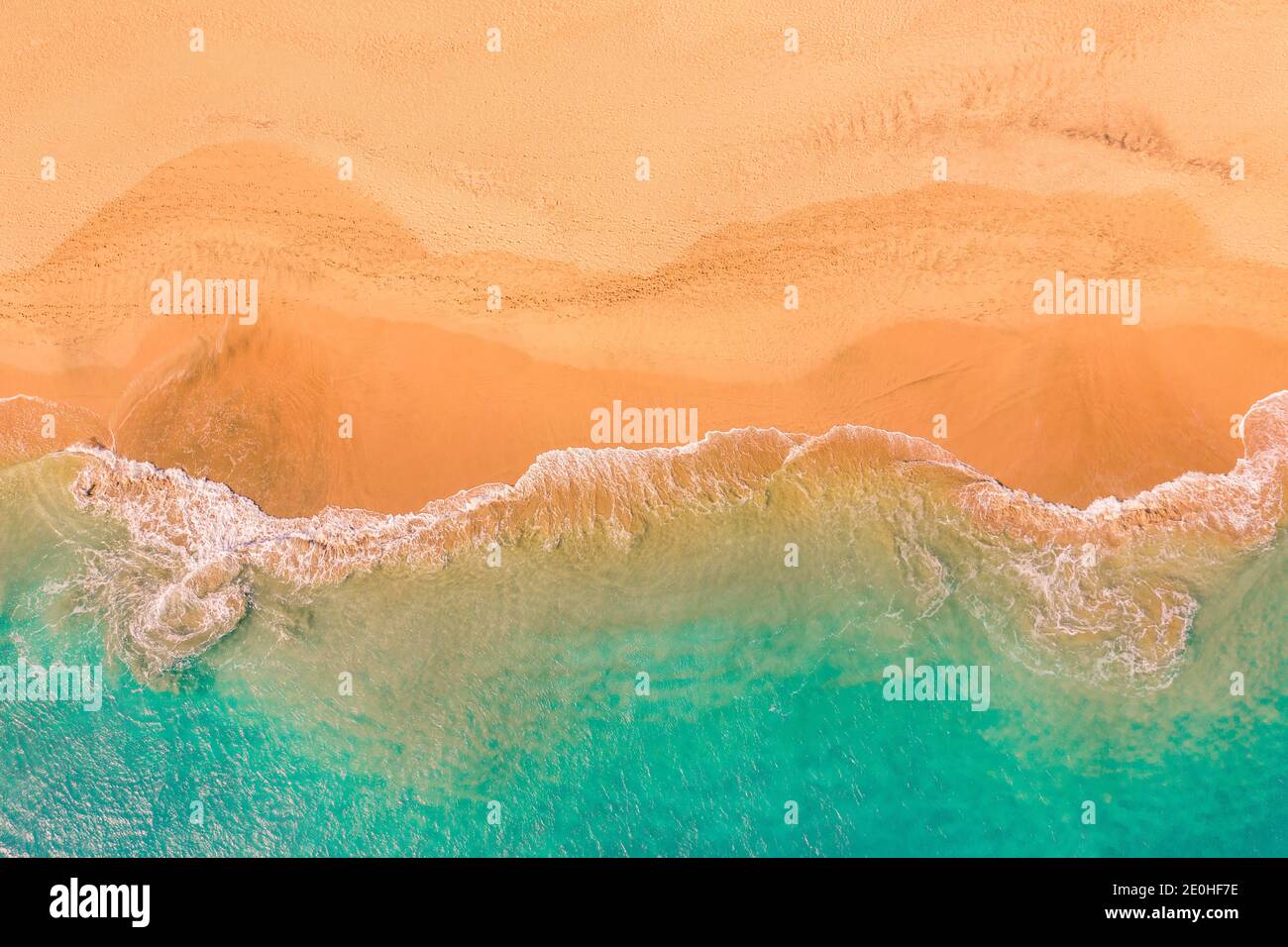 Aerial top down view of beautiful Atlantic ocean coast with crystal clear turquoise water and sandy beach, waves rolling into the shore Stock Photo
