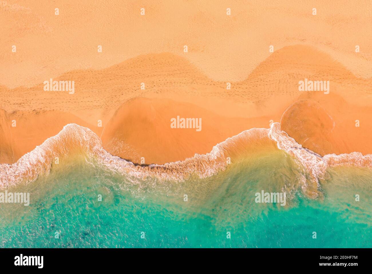 Aerial top down view of beautiful Atlantic ocean coast with crystal clear turquoise water and sandy beach, waves rolling into the shore Stock Photo