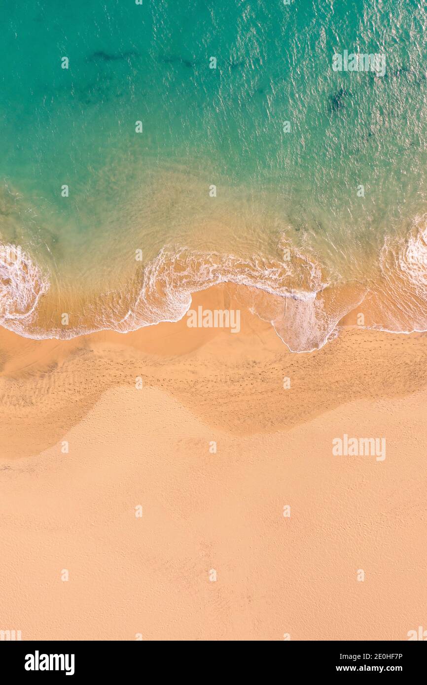 Aerial top down view of beautiful Atlantic ocean coast with crystal clear turquoise water and sandy beach, waves rolling into the shore Stock Photo