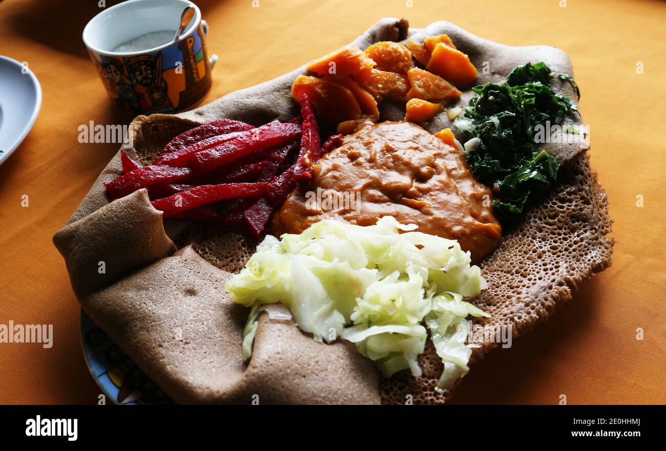 Traditional dish of mixed vegetable samplers on a bed of injera flatbread Stock Photo