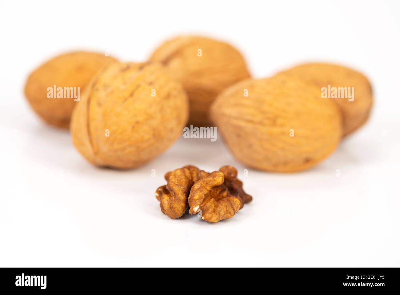 shelled walnuts and walnuts in shell on white background Stock Photo