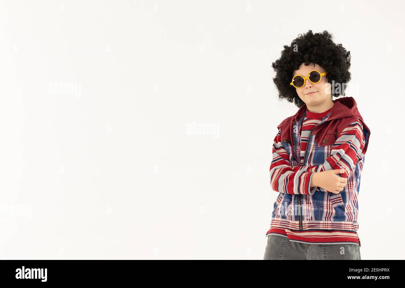 boy in afro hairstyle on a skateboard poses on a white background, boy in sunglasses young Stock Photo