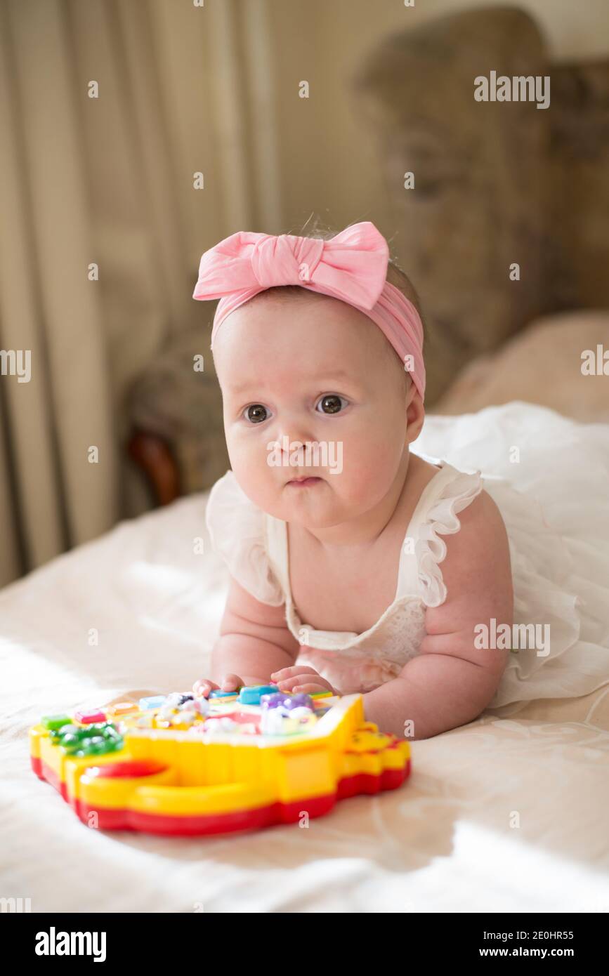 Baby girl (8 months) playing with maracas Stock Photo - Alamy