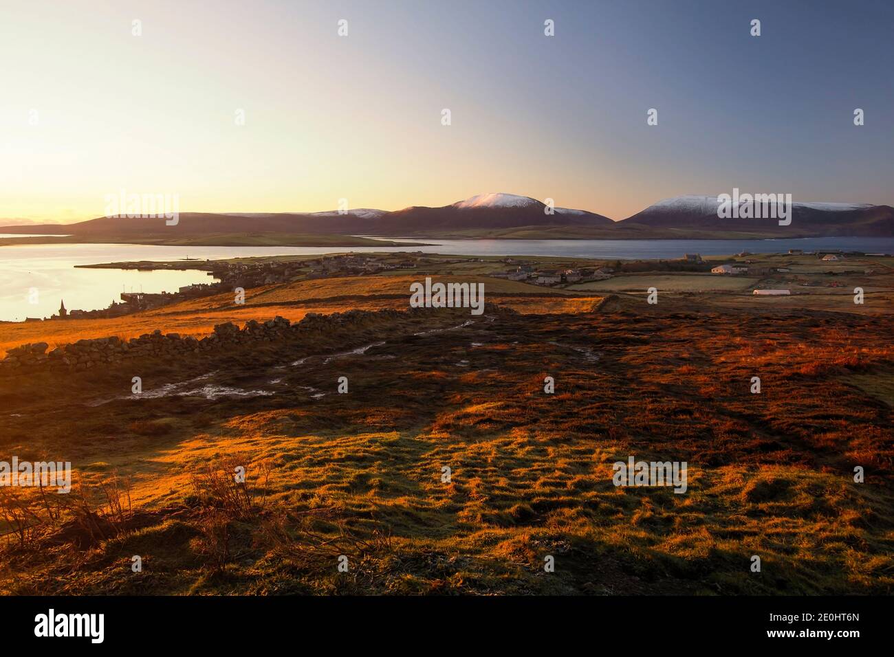 Aerial view of Orkney islands town Stromness in northern Scotland with sunrise light and snow on the hills Stock Photo